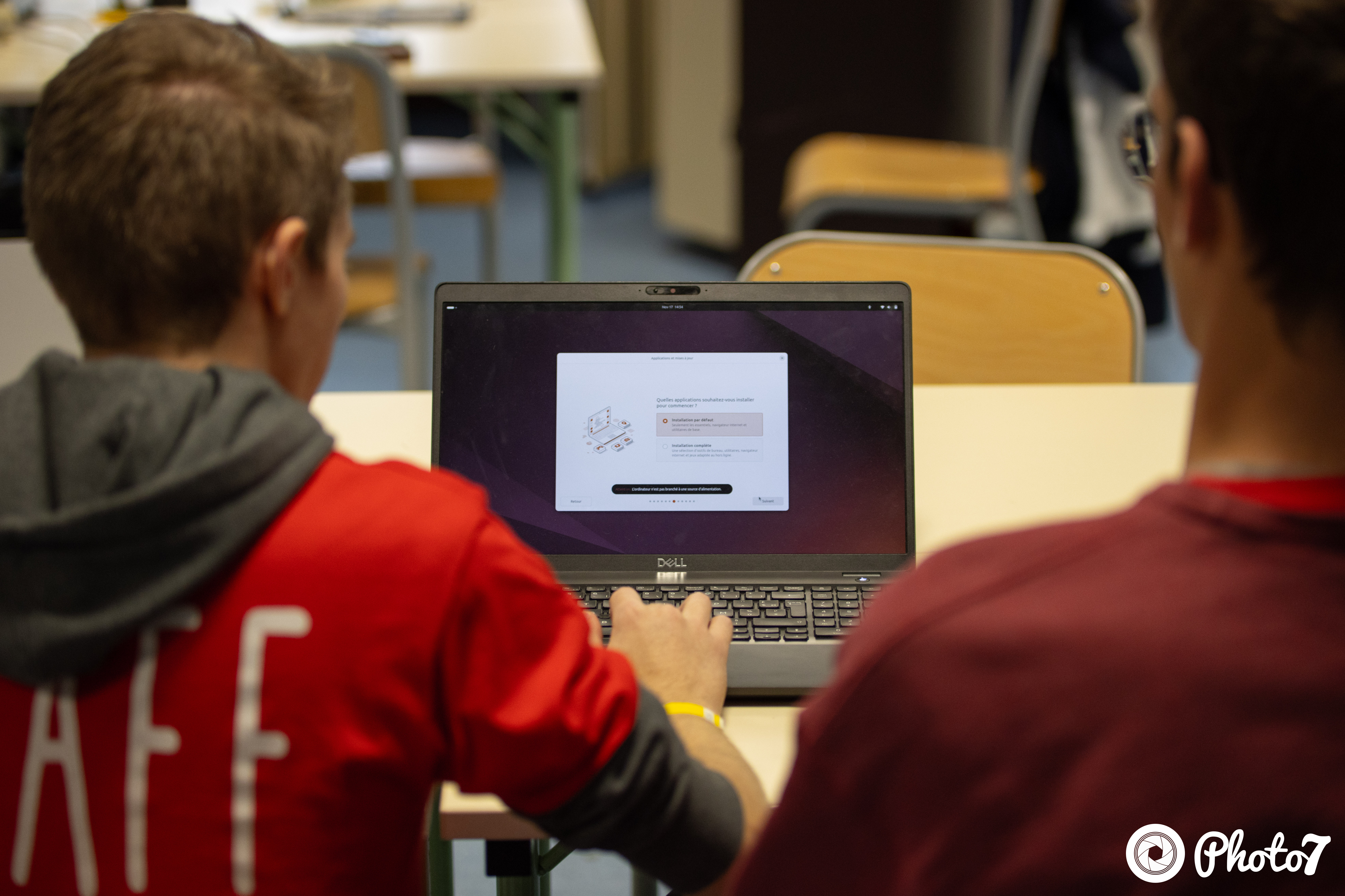Bénévole staff aidant à installer Ubuntu sur un ordinateur portable