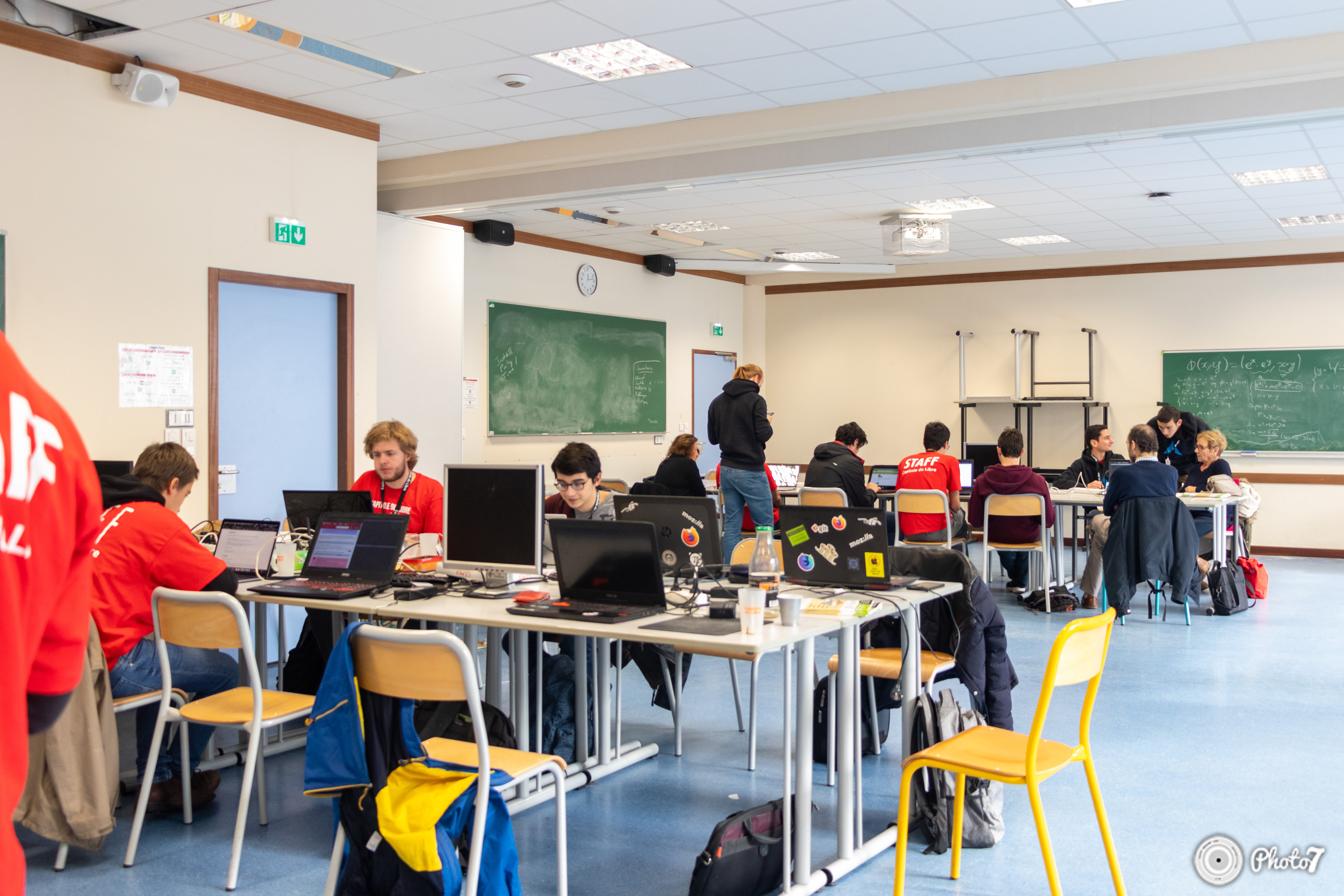 Vue d'ensemble de la salle de la LAN party avec participants sur leurs laptops